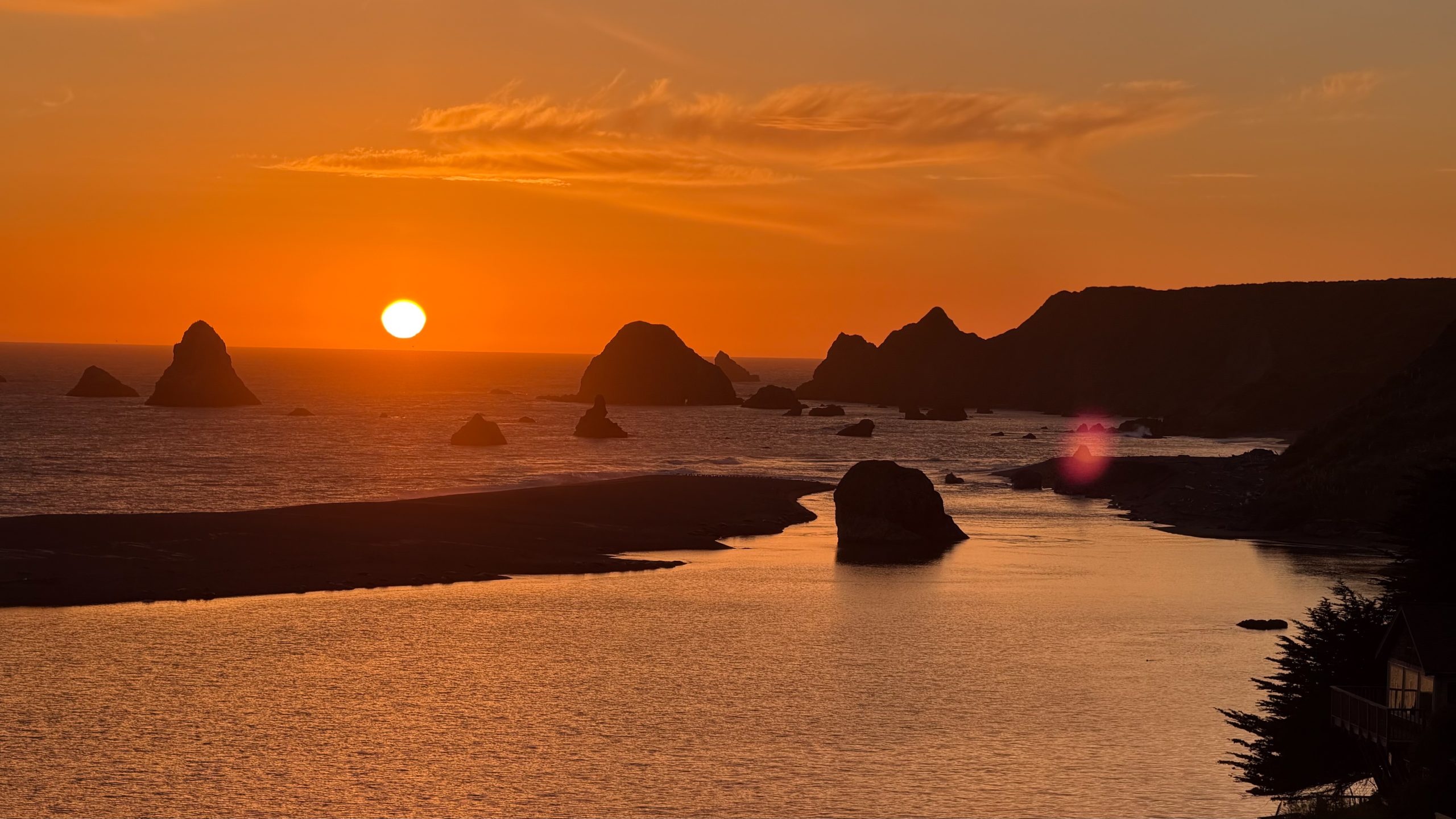 Sonoma Coast sunset - orange sky and sun going down into the ocean